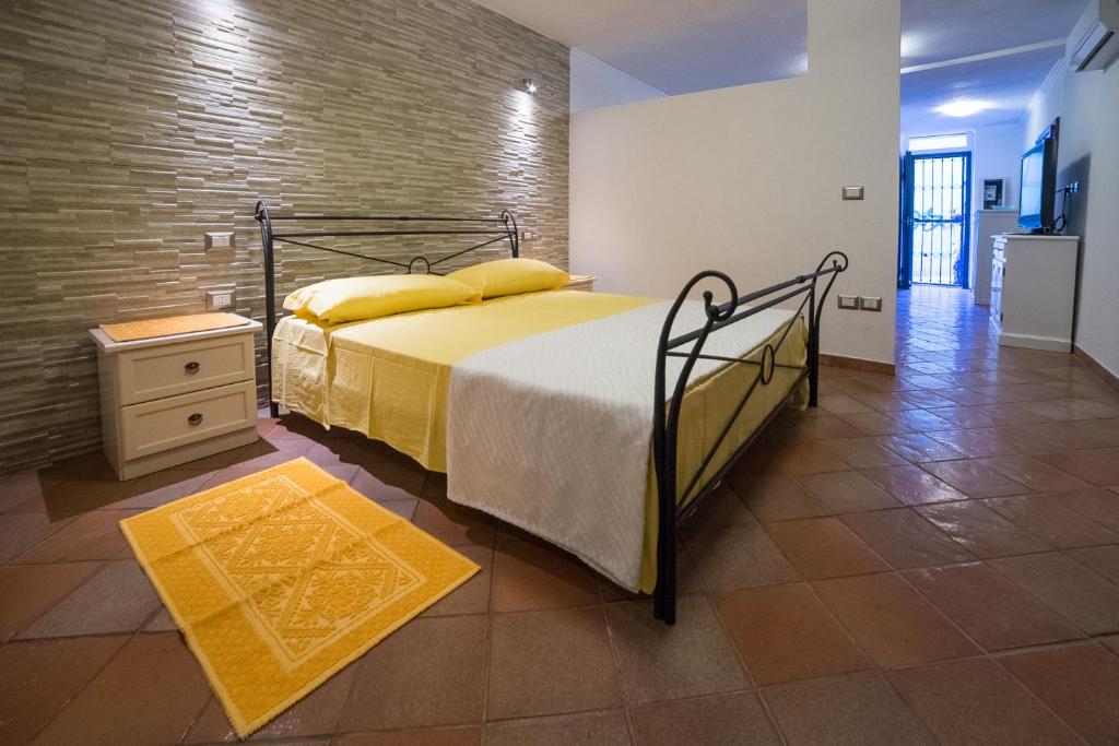 a bedroom with a bed and a brick wall at Casa Spiga in Cagliari