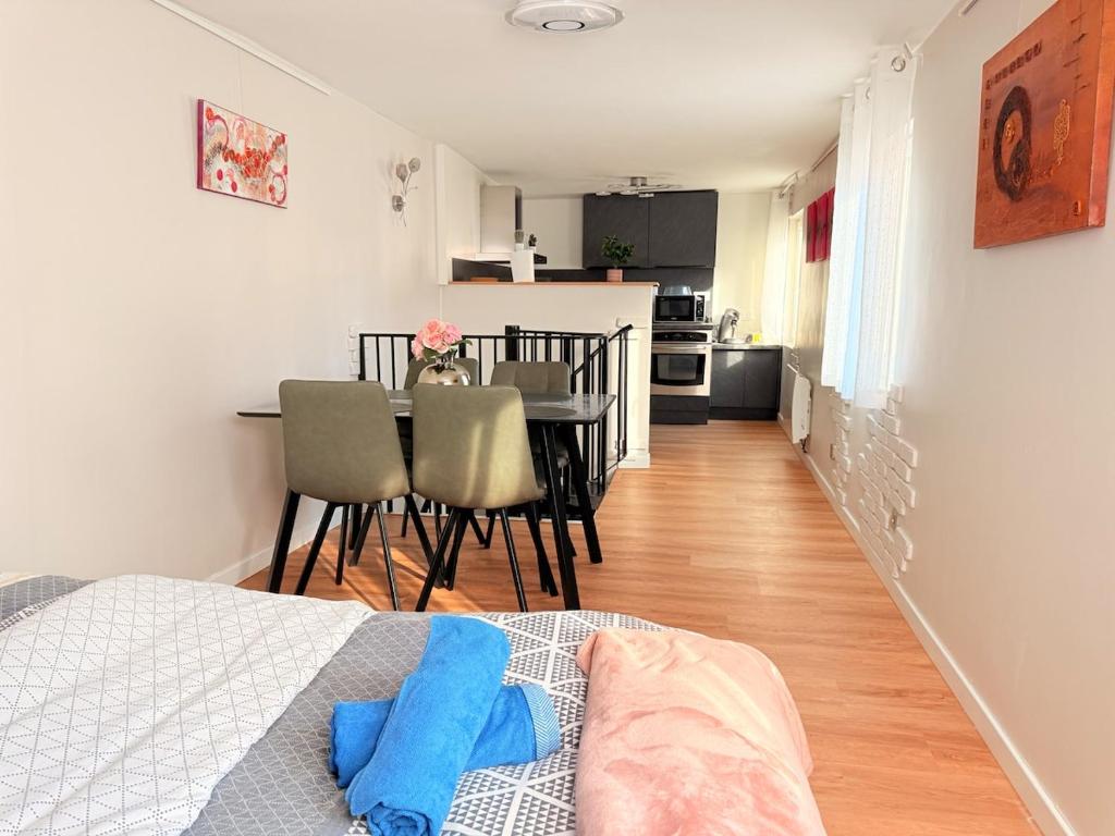 Cette chambre comprend un lit, une table et une cuisine. dans l'établissement Duplex Fleckenstein - Centre Historique de Haguenau, à Haguenau