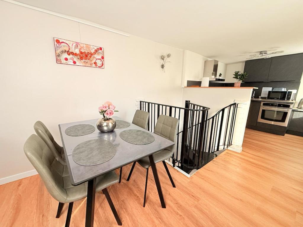 a dining room table with chairs and a kitchen at Duplex Fleckenstein - Centre Historique de Haguenau in Haguenau