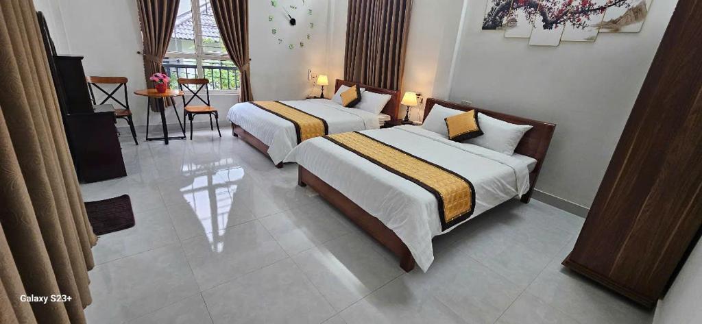 a bedroom with two beds and a table and chairs at Chi's House in Thôn Trường Giang