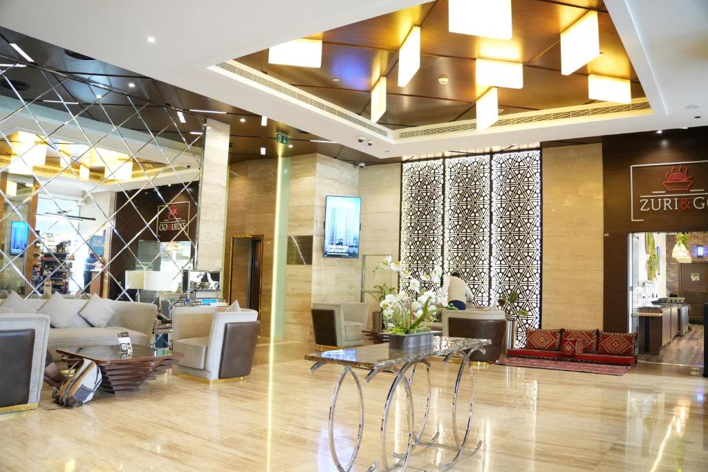 a lobby with couches and tables in a building at Treppan Hotel & Suites By Fakhruddin in Dubai