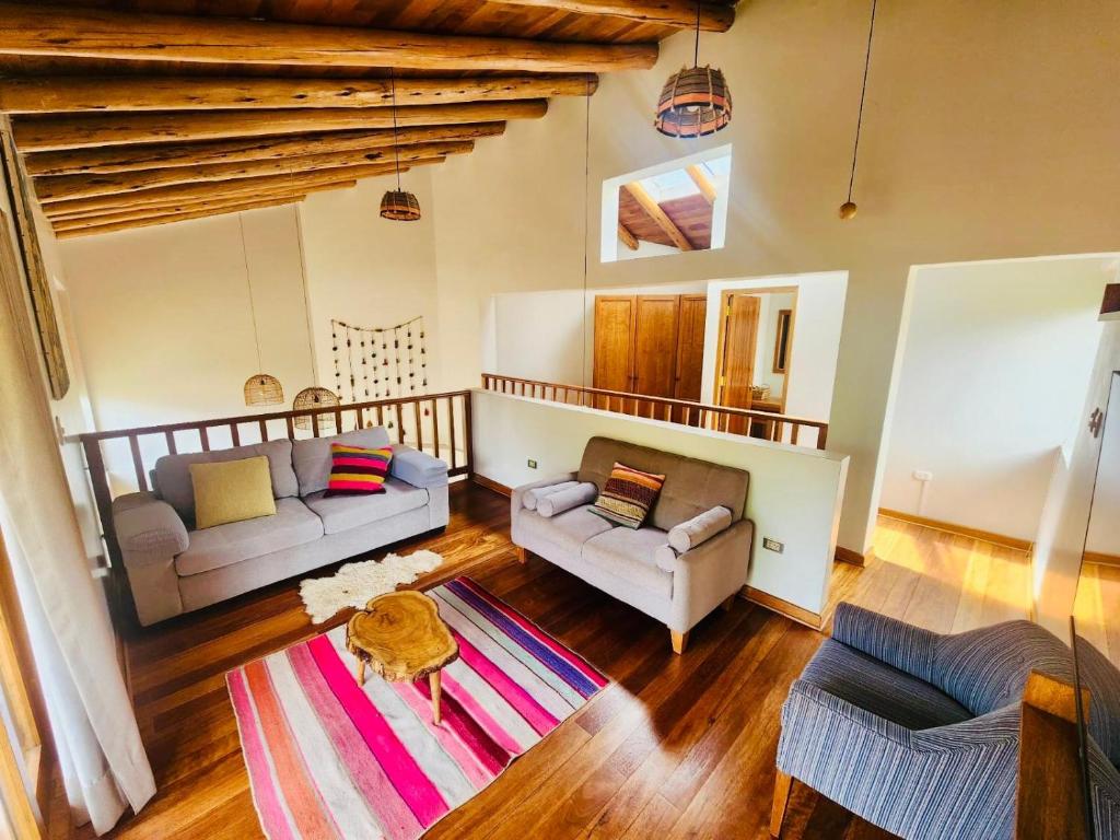 a living room with two couches and a rug at Tranquil creekside Bungalow in Sacred Valley Cusco in Cusco