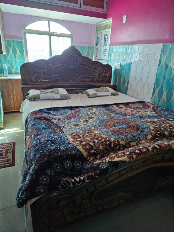 a large bed in a room with a colorful quilt at Texoya Zostellers Homestay in Bihār Sharīf