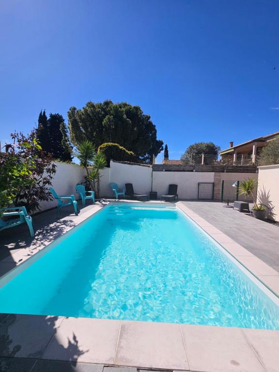 une piscine avec de l'eau bleue dans une cour dans l'établissement maison du sud, à Marsillargues