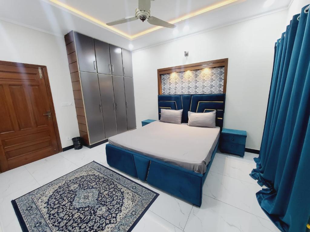 a bedroom with a blue bed and a door at Kashees Lodges in Islamabad