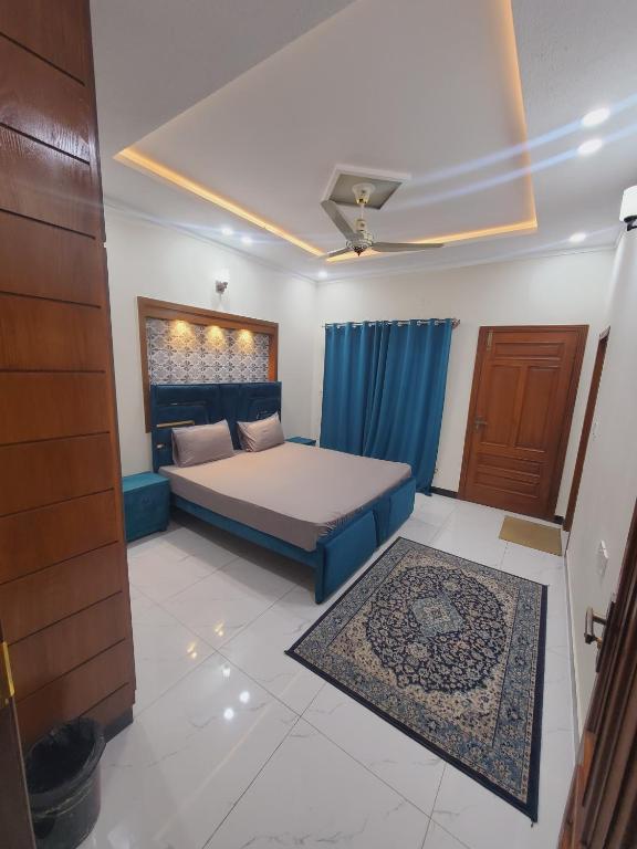 a bedroom with a bed with a blue bed frame at Kashees Lodges in Islamabad
