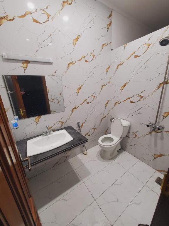 a bathroom with a toilet and a sink at Kashees Lodges in Islamabad