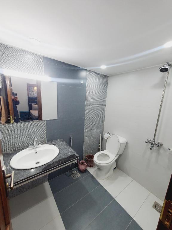 a bathroom with a sink and a toilet at Kashees Lodges in Islamabad