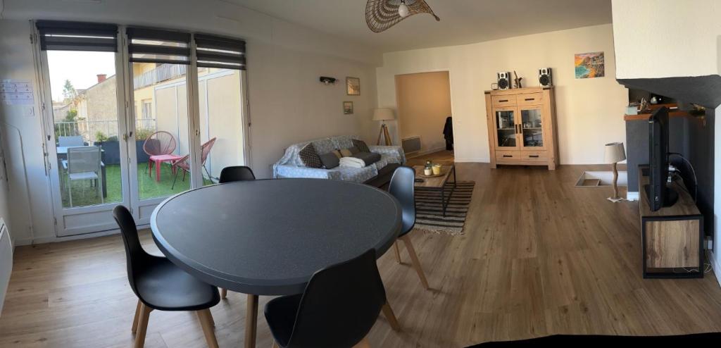 un salon avec une table et des chaises dans l'établissement les pieds dans l'eau, à Royan