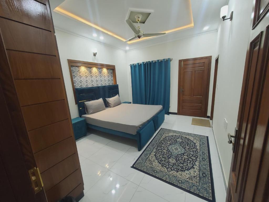 a small bedroom with a bed and a door at Kashees Lodges in Islamabad