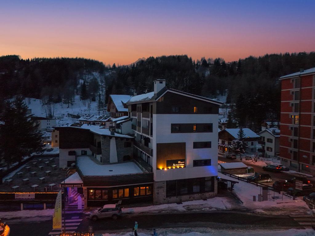 un edificio con las luces encendidas en una ciudad en Hotel Arlecchino - Dada Hotels, en Madesimo