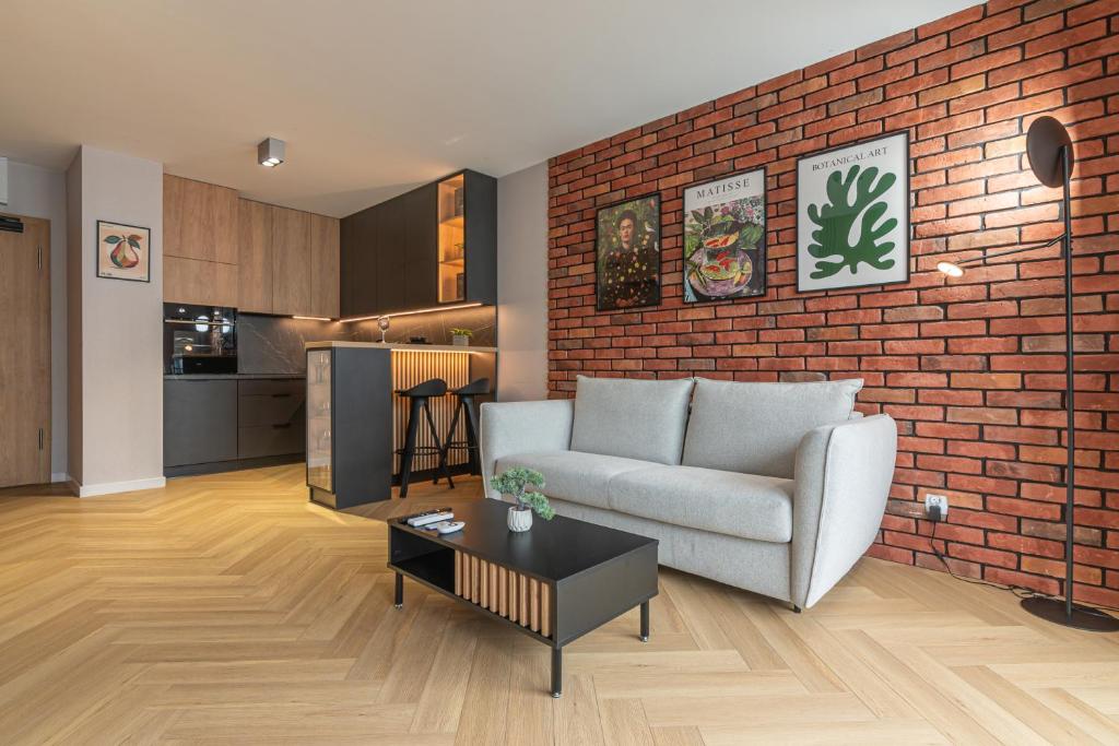 a living room with a couch and a brick wall at River Side Residence in Oświęcim