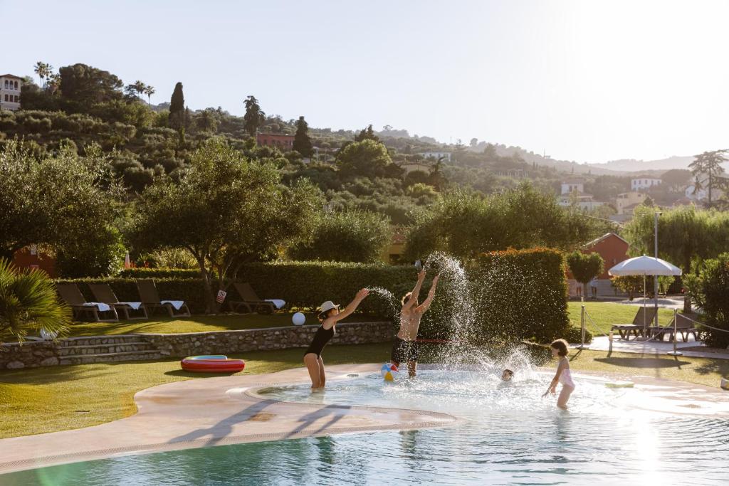 a group of children playing in a fountain in a pool at ReBi Village in Imperia