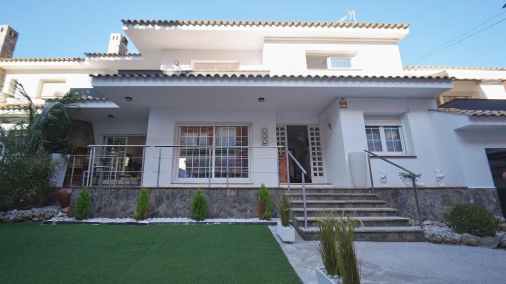 ein weißes Haus mit einem Rasen davor in der Unterkunft SeaHomes Vacations - Villa Chill & Pool 200m Beach in Pineda de Mar