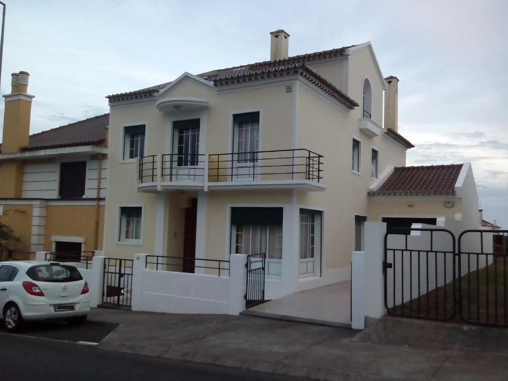 a white car parked in front of a house at Casa Quinta do Marquês in Ponta Delgada
