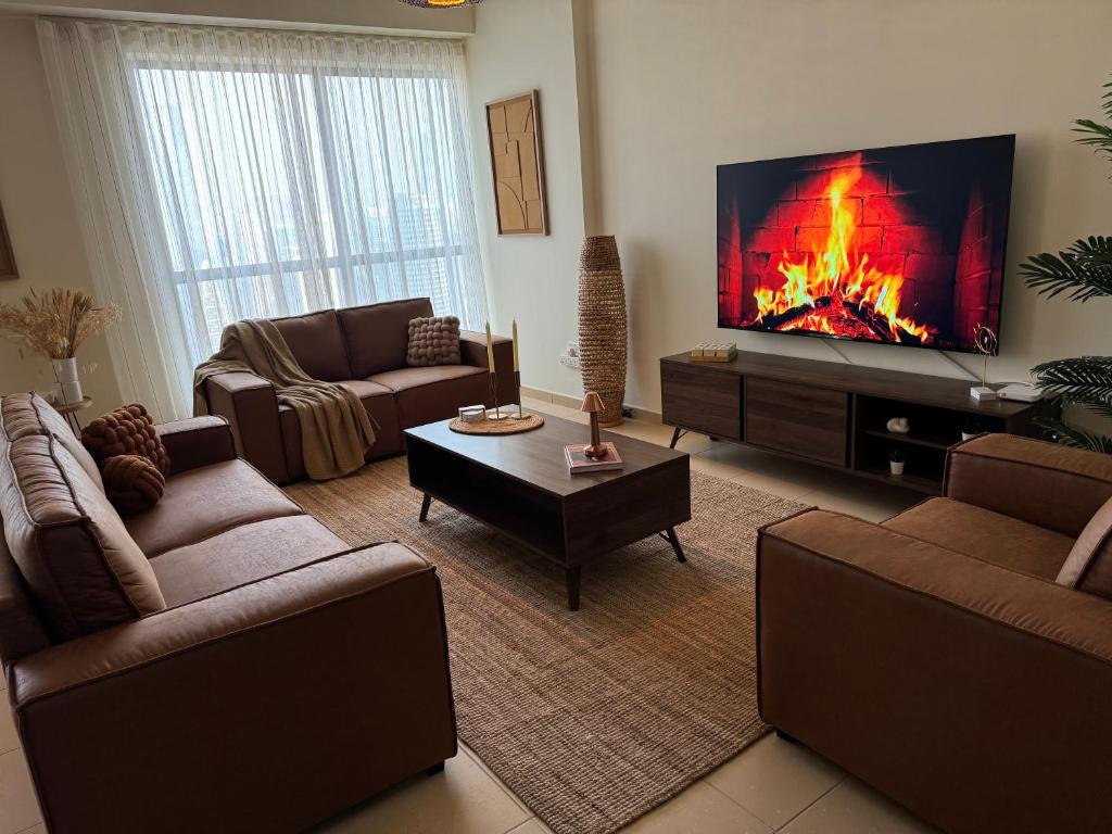 a living room with a large tv and a fireplace at Best view homes in Dubai