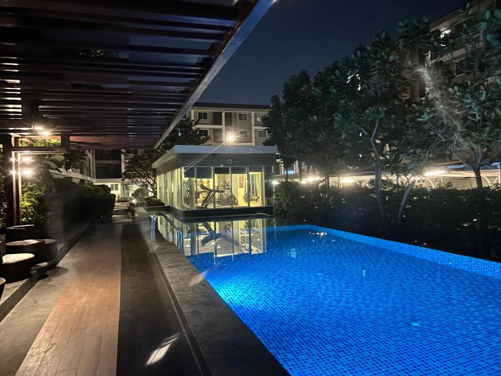 ein Schwimmbad in der Mitte eines Gebäudes in der Nacht in der Unterkunft Peaceful Stay at MT Khlong Luang Self-Check-in เช็คอินด้วยตนเอง in Khlong Luang