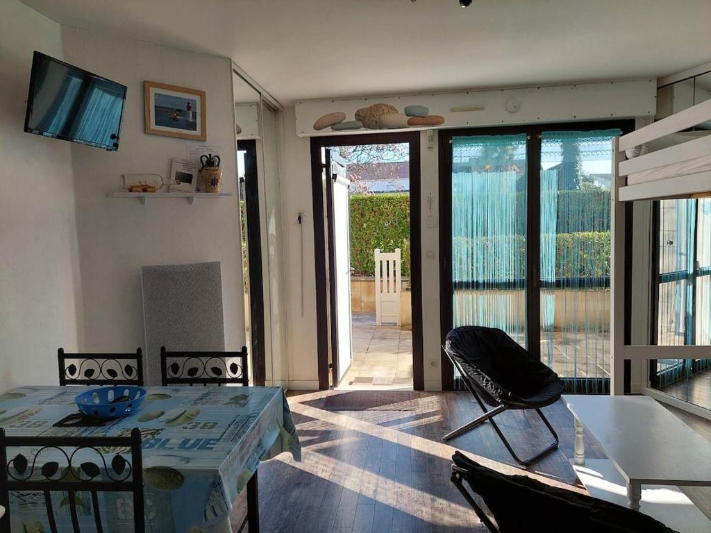 un salon avec une table et des chaises et un balcon dans l'établissement Ty Charcot, à Bénodet