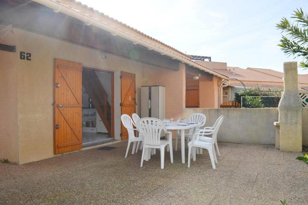 une table et des chaises sur le patio d'une maison dans l'établissement NP180-062 Pavillon 2 pièces mezzanine Narbonne Plage, à Narbonne-Plage
