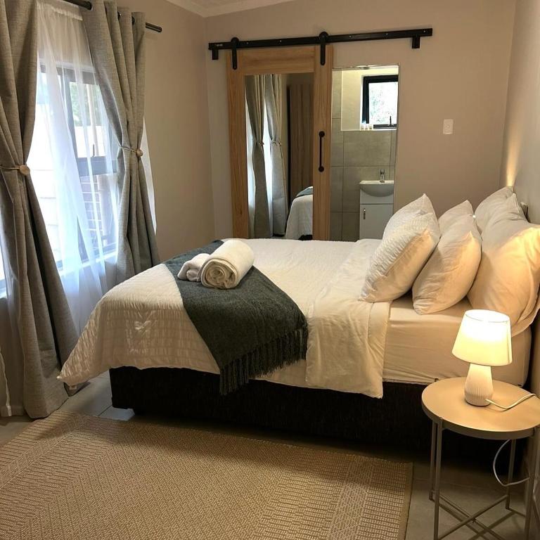 a bedroom with a bed with pillows and a window at Levangrey in George