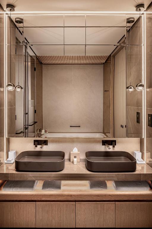 a bathroom with two sinks and a large mirror at Amathus Beach Hotel Limassol in Limassol