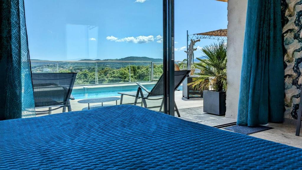 une chambre avec un lit et une vue sur une piscine dans l'établissement Homekeeper 3 villas récentes vue mer piscine privée, à Conca