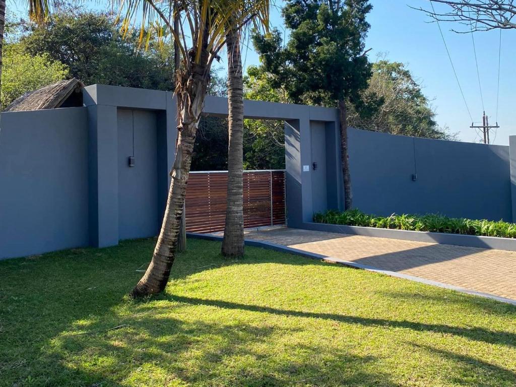 a house with two palm trees in a yard at Ndumu Safari Resorts in Jozini