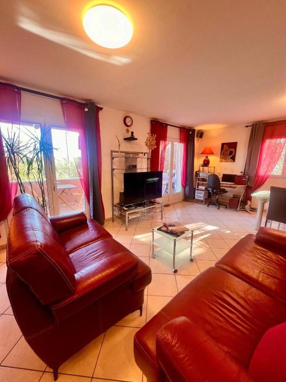 un salon avec deux canapés en cuir et une télévision dans l'établissement Maison Ondella, proche Santa Giulia, à Porto-Vecchio