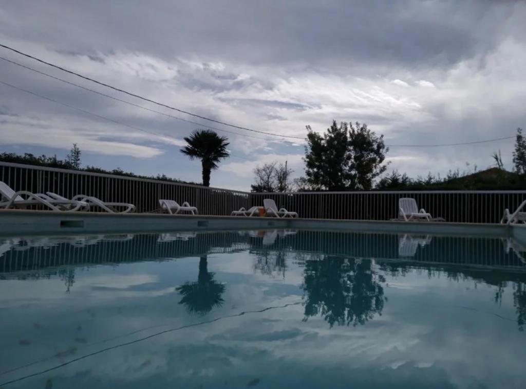 - une piscine avec des chaises et de l'eau dans l'établissement Les Verdisses Studio Cabine, à Agde
