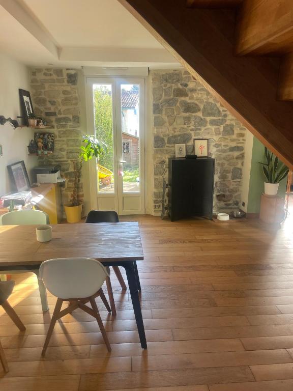 un salon avec une table et des chaises en bois dans l'établissement Maison mitoyenne avec jardin à Biarritz, à Arcangues