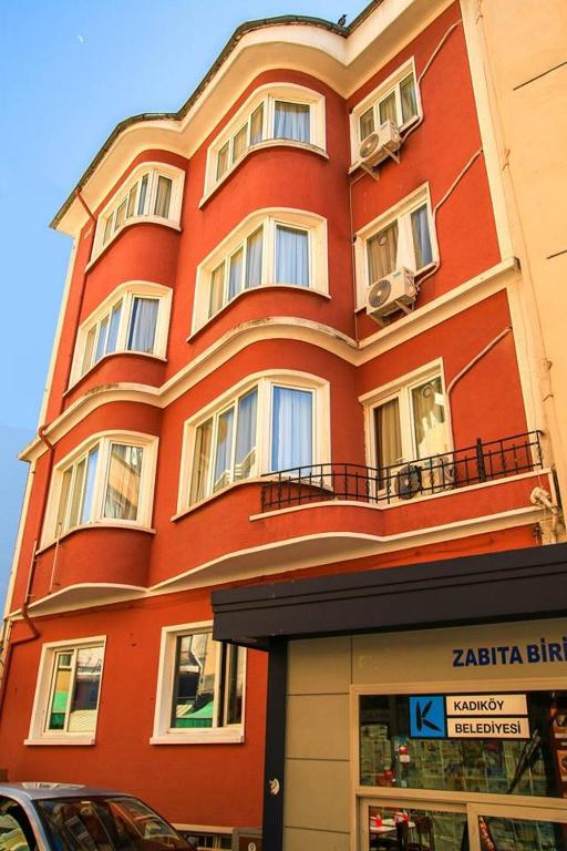 a large red building with windows on a street at Armoni City Otel Kadıköy in Istanbul