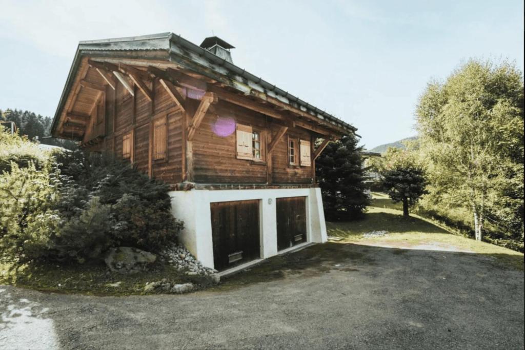 une maison en bois avec un garage en face de celle-ci dans l'établissement T5 cottage with balconies in Demi-Quartier, à Demi-Quartier
