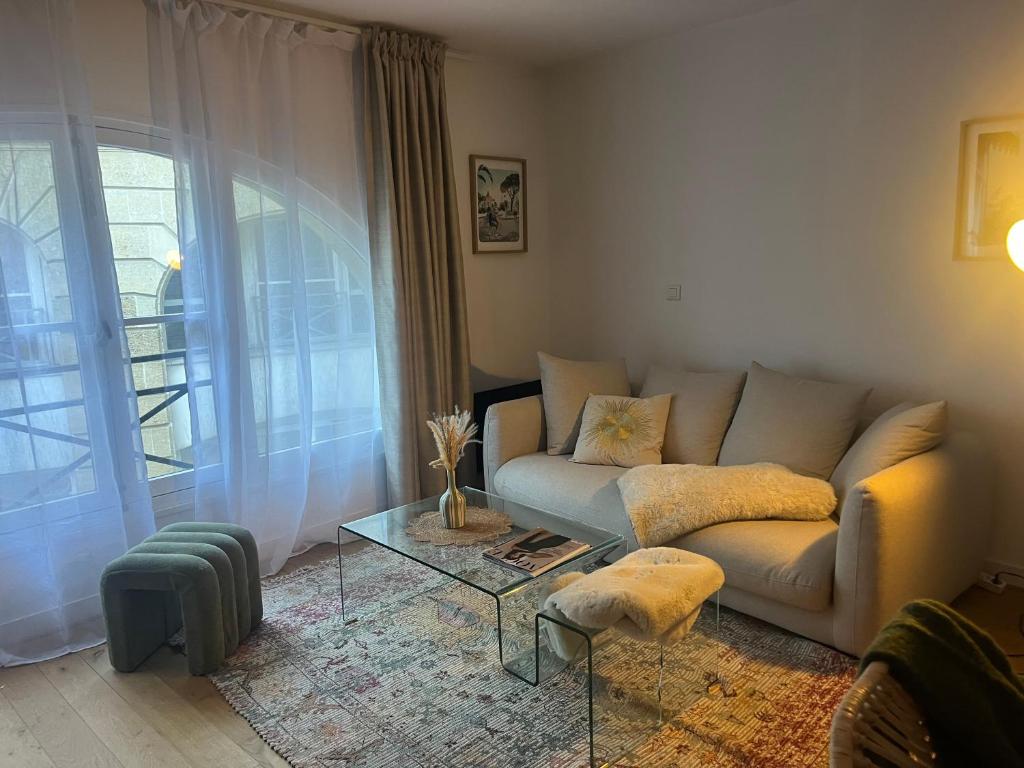 un salon avec un canapé et une table en verre dans l'établissement Appartement cosy au cœur des chartrons, à Bordeaux