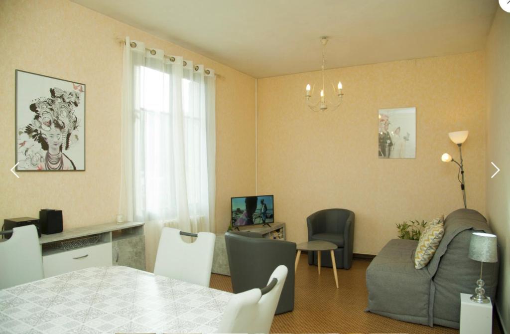 un salon avec une table et un canapé dans l'établissement Bel appartement lumineux, à Royat