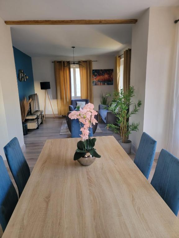 une salle à manger avec une table en bois et des chaises bleues dans l'établissement Chez Carine et Jonathan, à Gérardmer