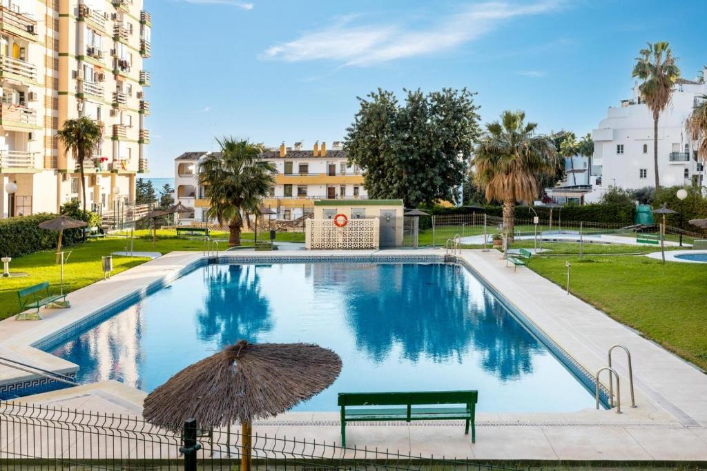 basen z ławką i parasolem w obiekcie Casa Zoe - Apartamentos en Suite Budha - Buenas vibras! Edificio #LasNaciones w mieście Benalmádena