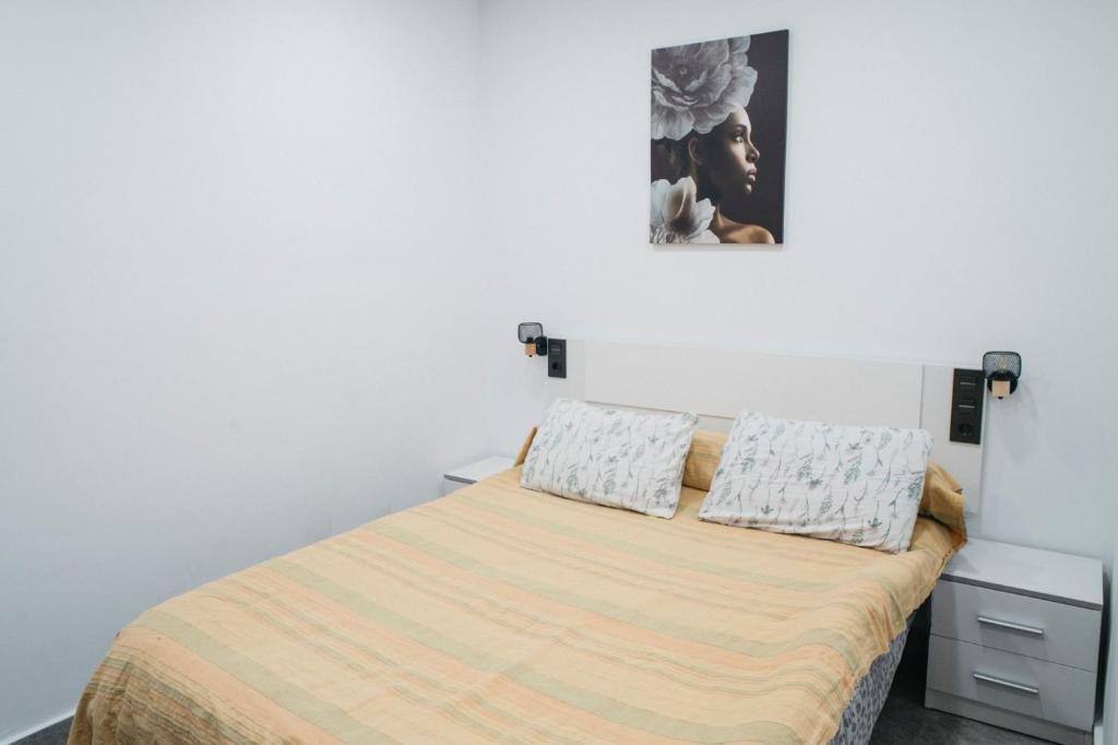 Un dormitorio con una cama con dos almohadas encima. en Apart LA PLANA II, en Castellón de la Plana