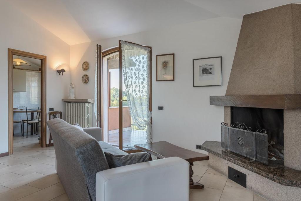 Una sala de estar con un sofá y una chimenea. en Casetta dei Daini, en Orio al Serio