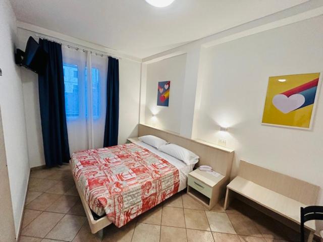 a small bedroom with a bed and a window at Hotel Aurora in San Vincenzo
