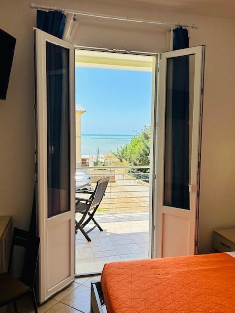 a bedroom with a door open to a patio at Hotel Aurora in San Vincenzo