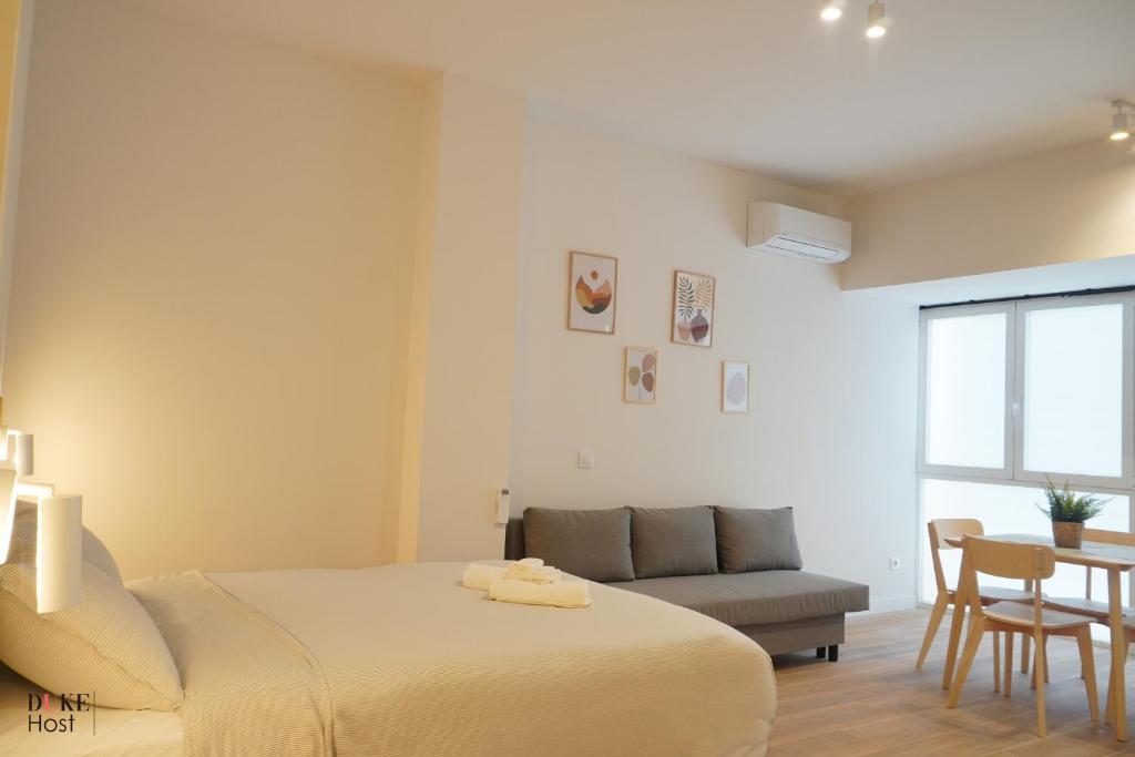 een slaapkamer met een bed, een bank en een tafel bij CH 5Torres in Madrid