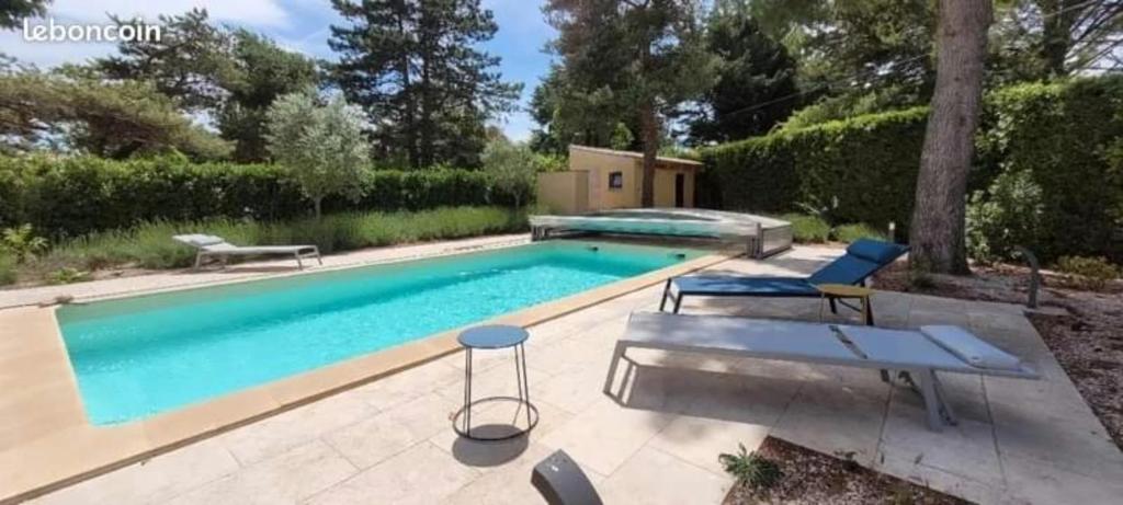une piscine avec deux chaises et une table dans l'établissement Mas Jaune aux volets Gris, au Thor