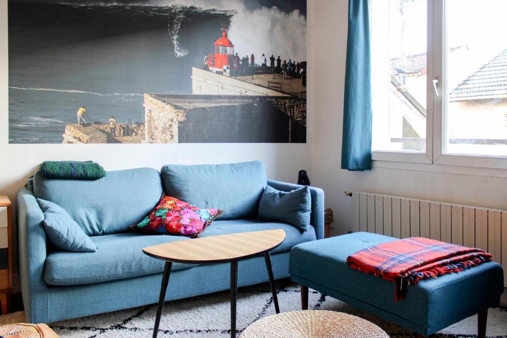 un salon avec un canapé bleu et une table dans l'établissement Bright T2 just outside the City of Light, à Aubervilliers