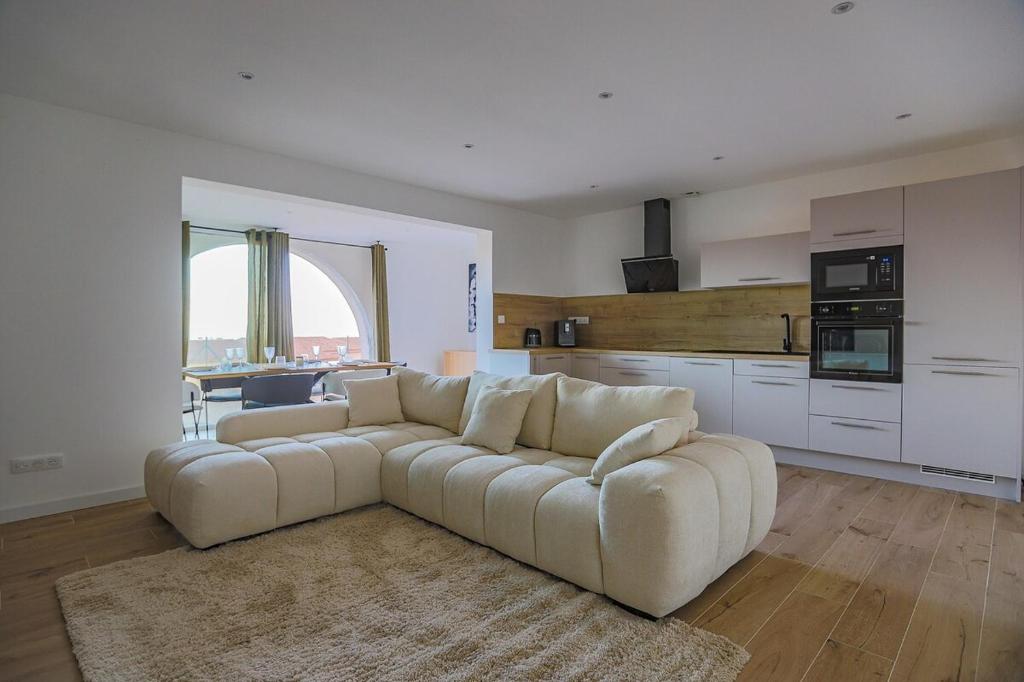 un salon avec un canapé et une cuisine dans l'établissement Casa Mia-Appartement Standing-Monticello, à Monticello