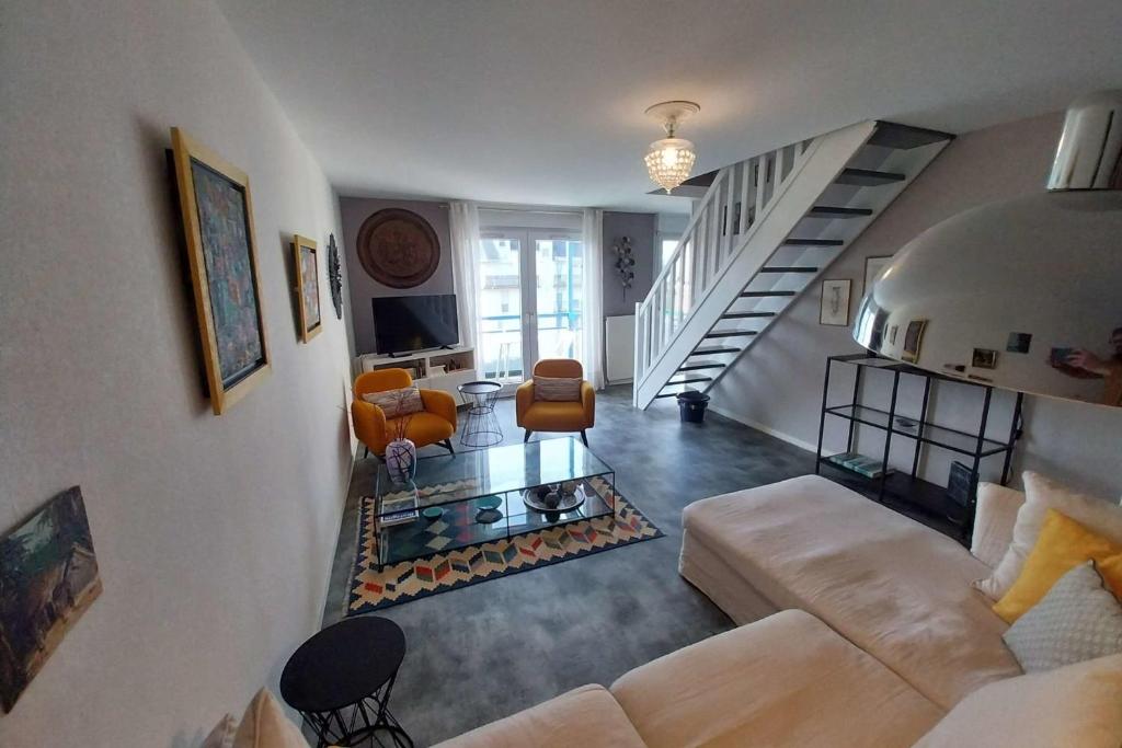 ヴァンヌにあるSpacious apartment with balconyのソファと階段のあるリビングルーム