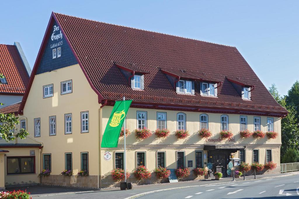 un gran edificio amarillo con techo rojo en GROSCH Brauhotel & Gasthof en Rödental