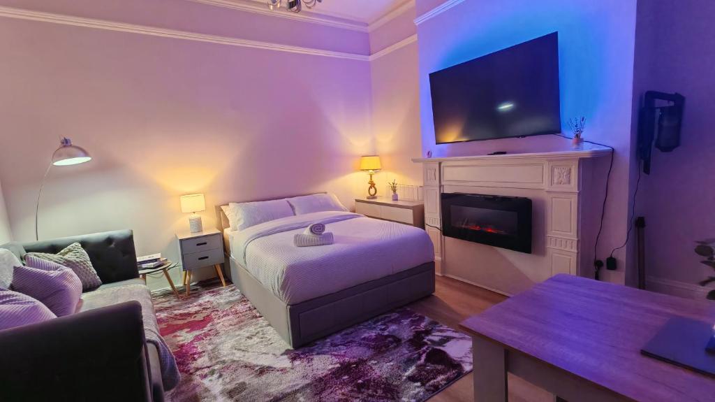 a bedroom with a bed and a fireplace with a tv at Stylish York Studio in York