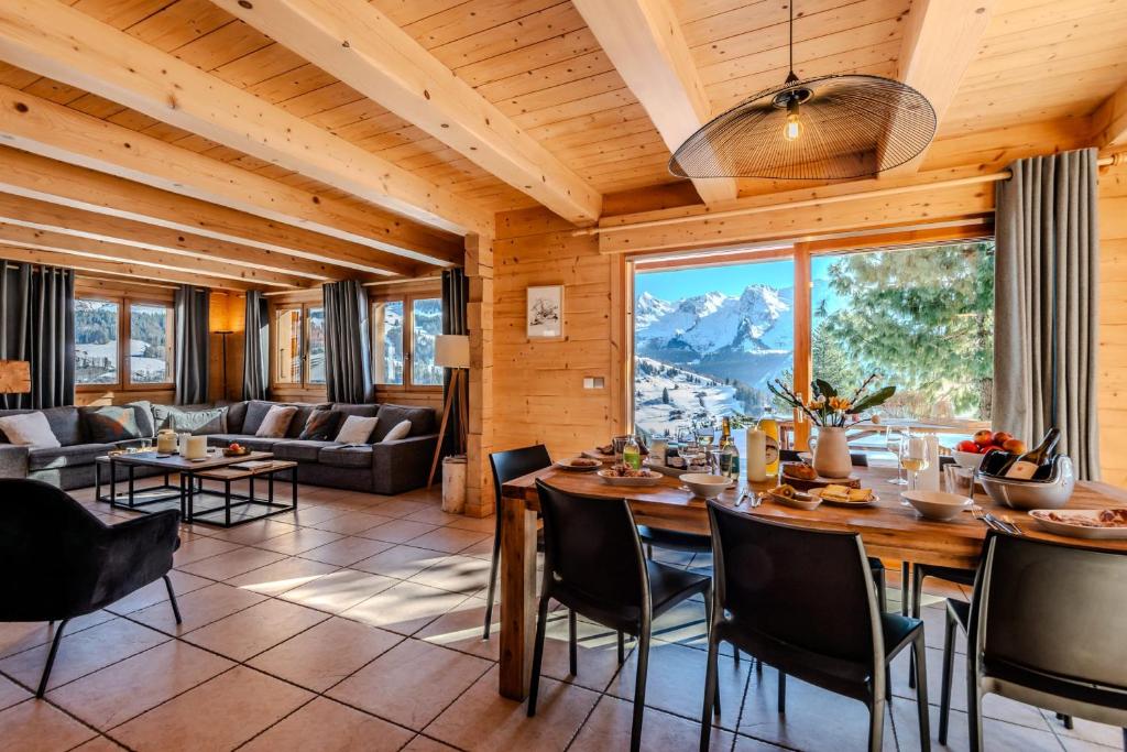 a living room with a table and chairs and a couch at Slow Chalet Mont Real - Le Grand Bornand - 3km from slopes Chinaillon in Le Grand-Bornand