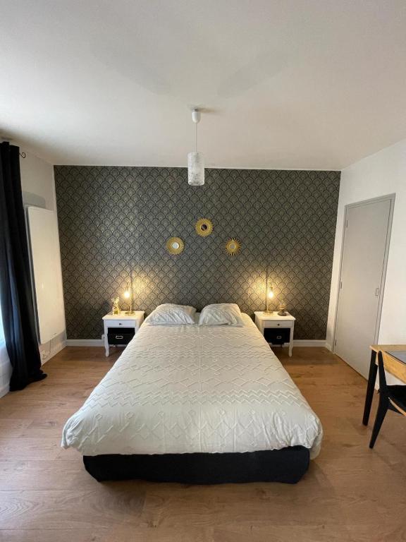 - une chambre avec un lit et deux tables avec des lumières dans l'établissement Au coeur de Chantilly, près de Paris et du Parc Astérix, à Chantilly