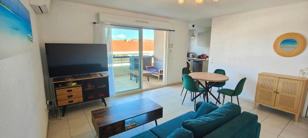 un salon avec un canapé, une table et une télévision dans l'établissement Flat in Fréjus with balcony air co and parking, à Fréjus